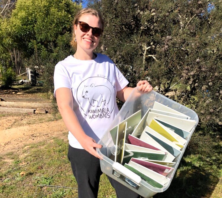 melinda holding a container of mange flaps made using corflute